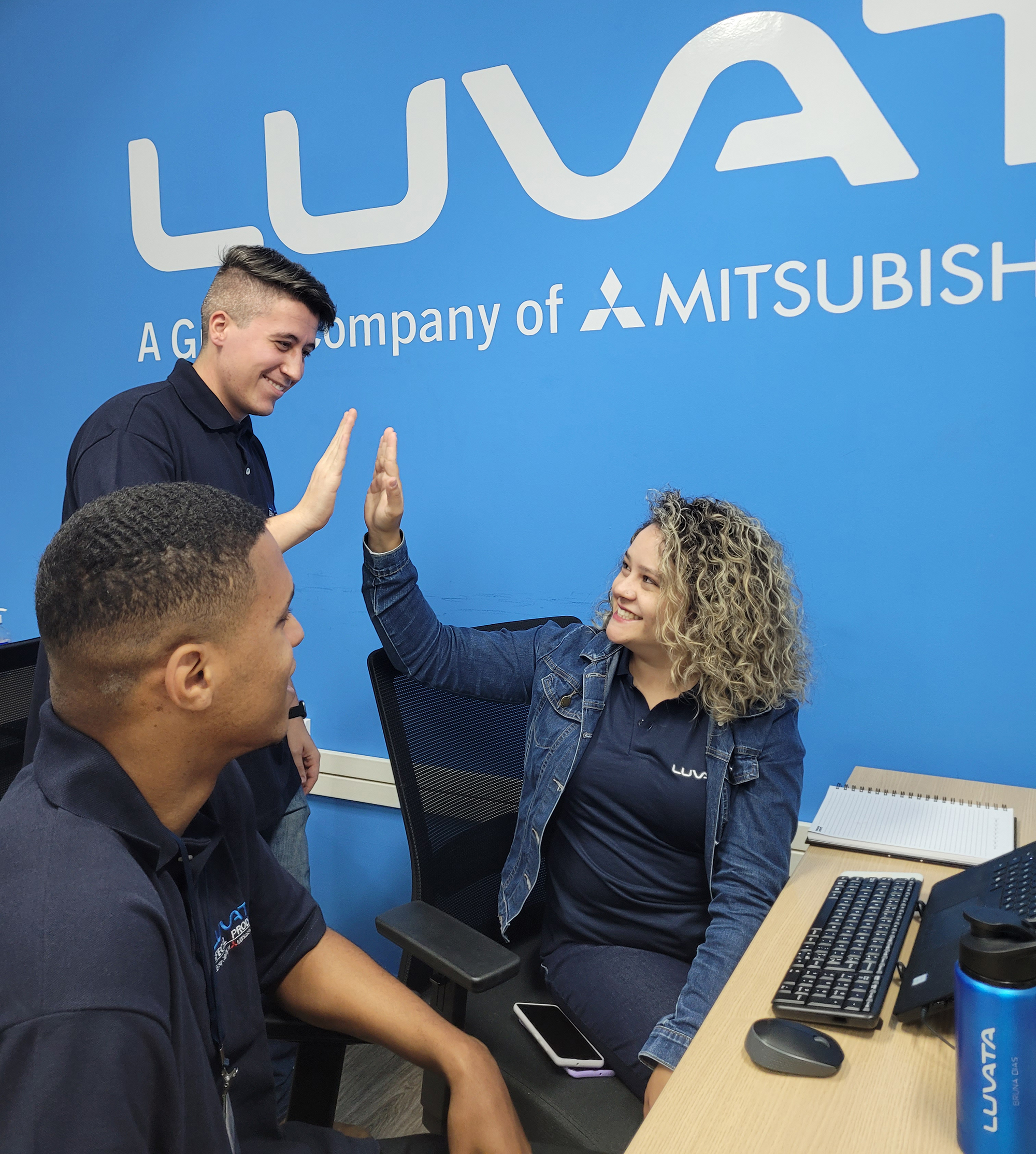 Three happy employees working in an office