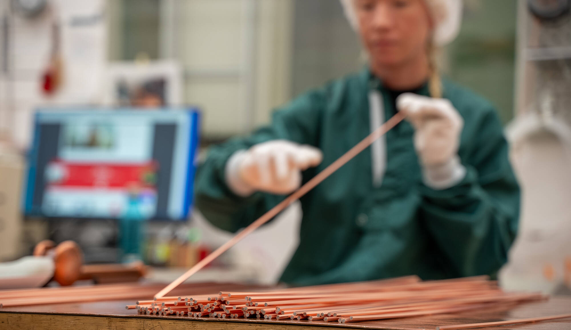 Employee checking the quality of a superconductor wire